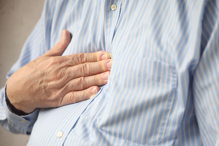 Man touching his chest as he experiences symptoms of indigestion