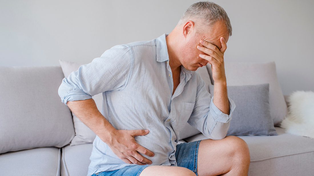 man holding his stomach in discomfort