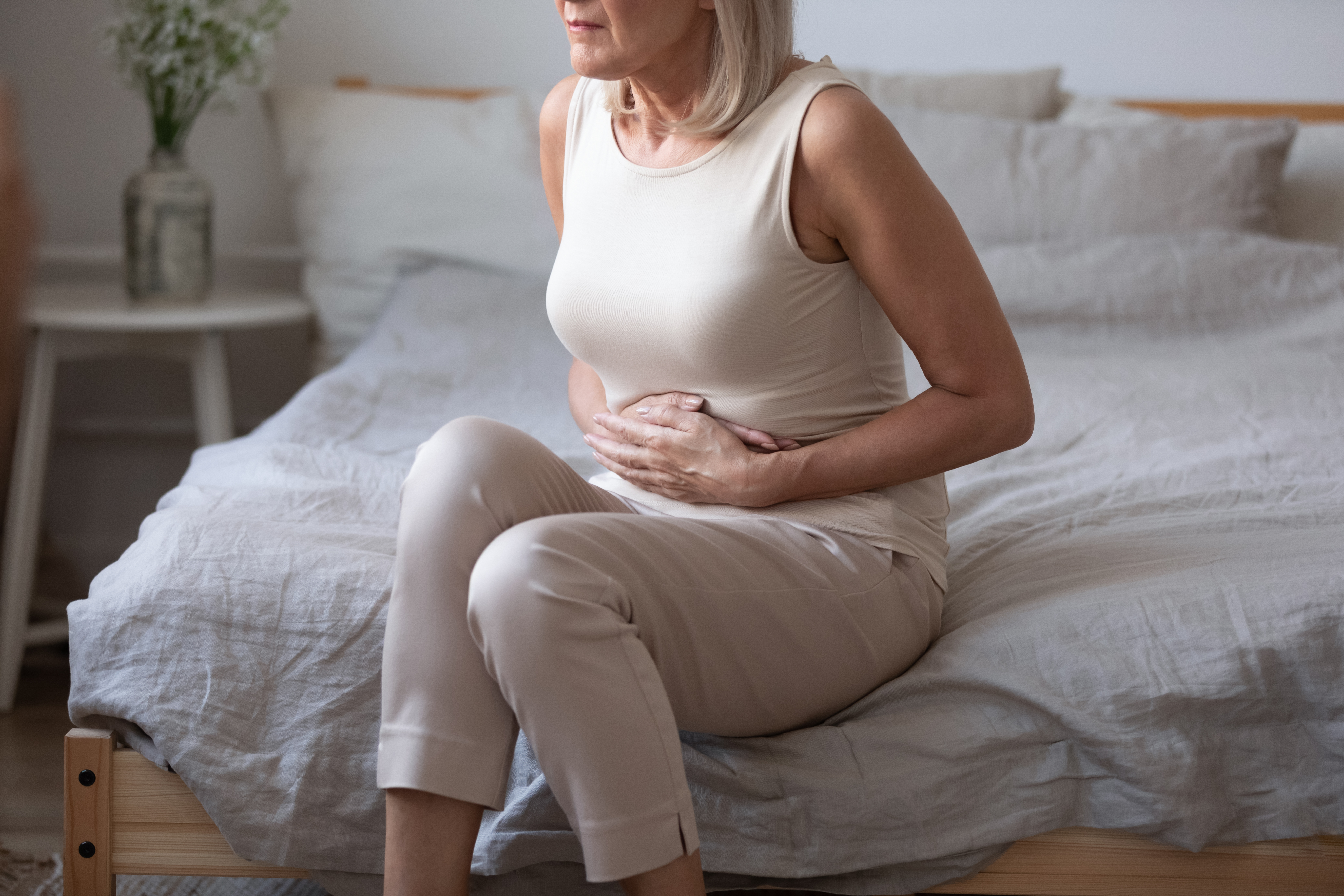 women holding her stomach due to abdominal pain