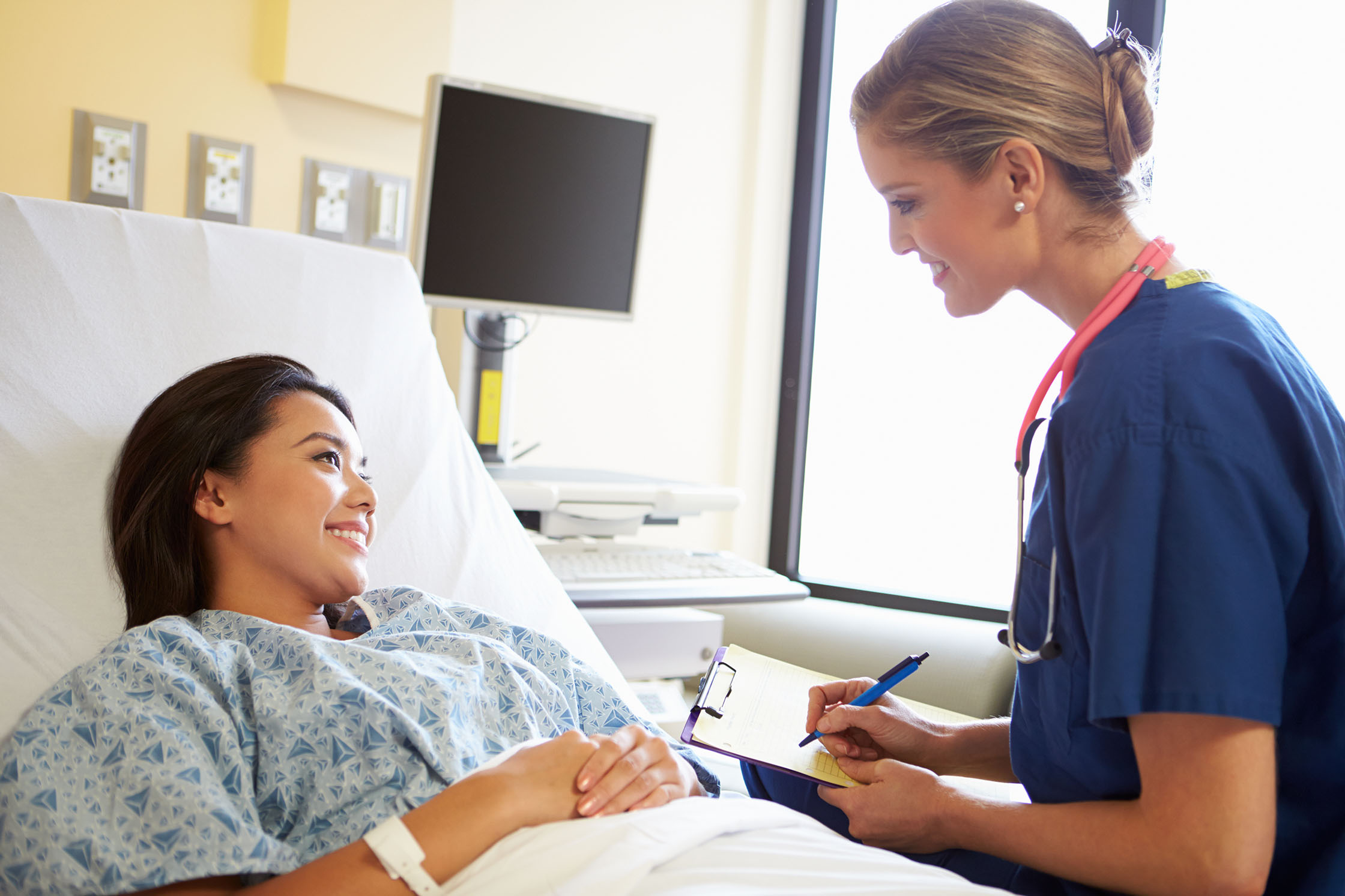 woman smiling with physician taking notes