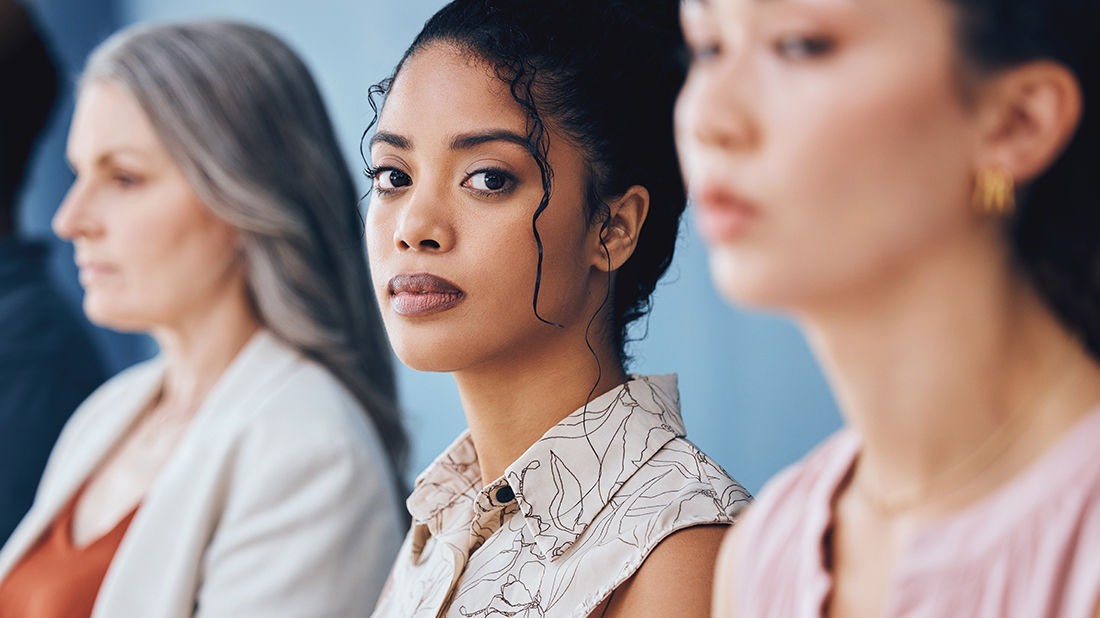 Woman looking at the camera seriously with 2 other women